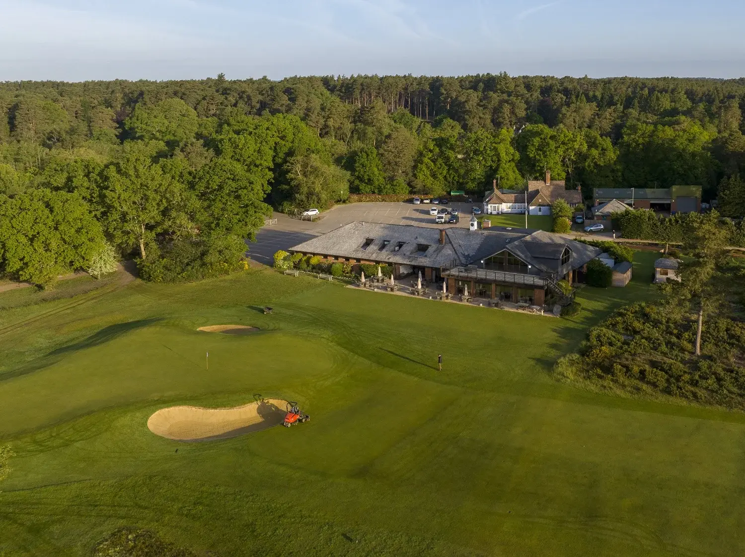 The clubhouse and closing holes at Hankley Common Golf Club in Surrey in evening light
